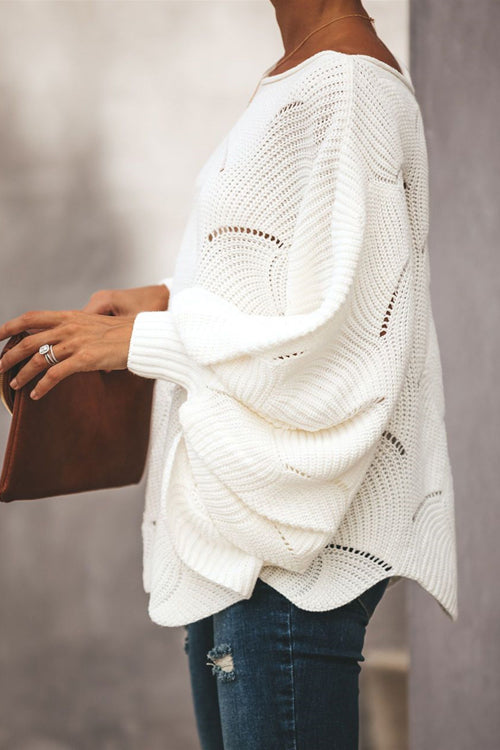 White oversized knit sweater with bat-wing sleeves and curved stitched design