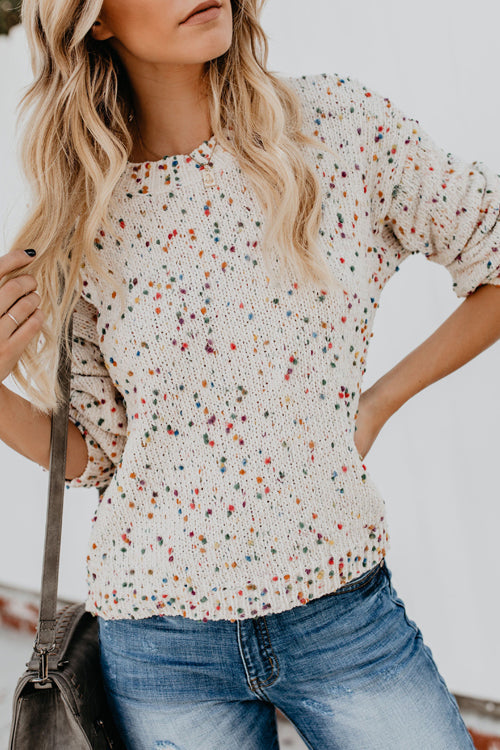 Beige dot-pattern knit sweater with crew neckline and short, cuffed sleeves