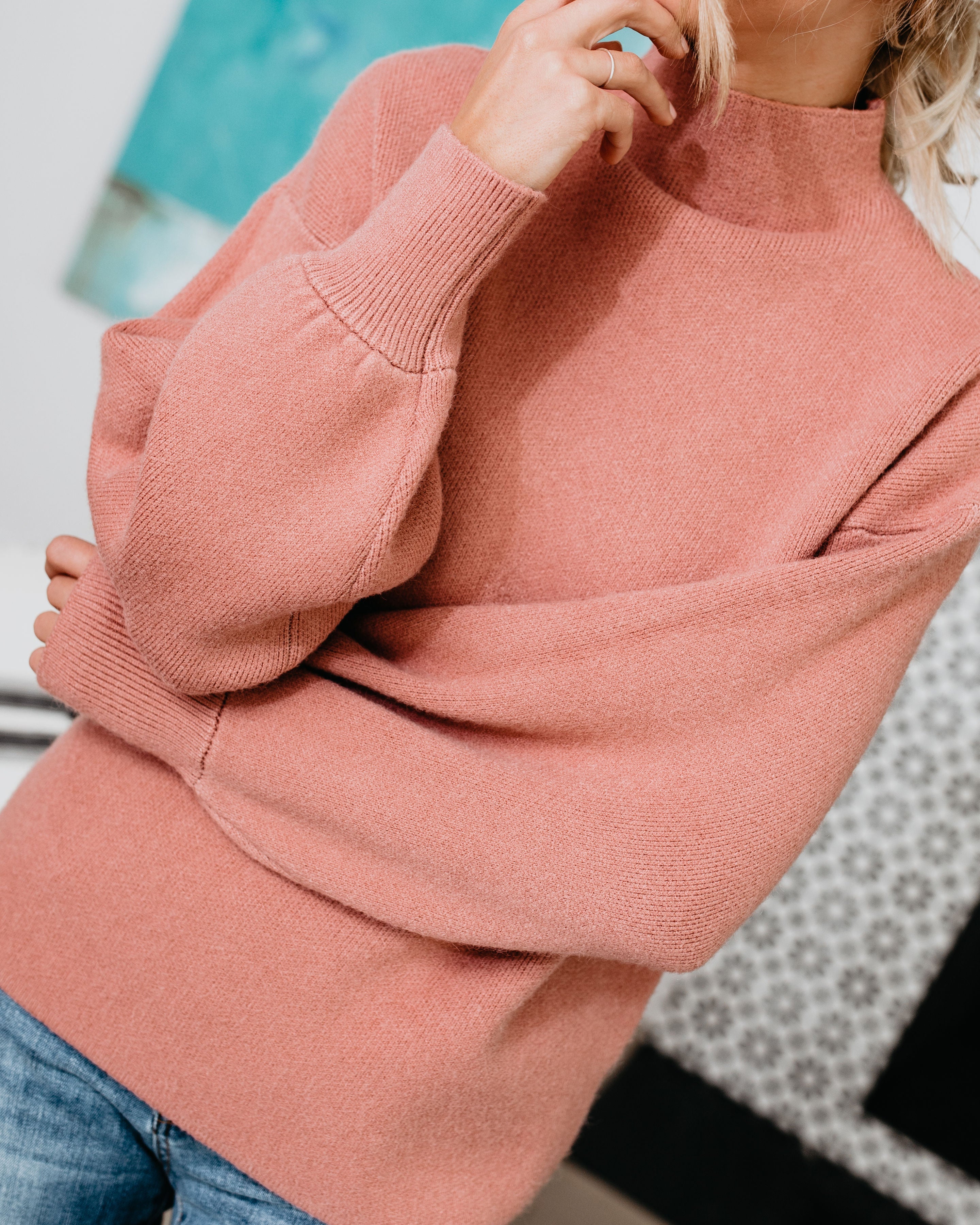 Close-up of blush pink mock neck sweater with ribbed knit cuffs