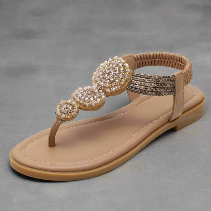 Beige flat thong sandals with braided ankle strap and gold beaded round medallions