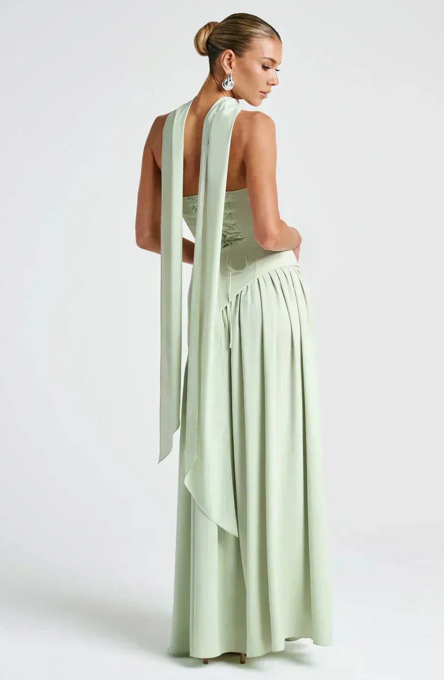 Sage green maxi dress with high halter straps, layered skirt, and trailing back drape