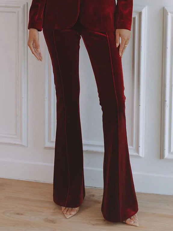 Women’s red velvet blazer with flared trouser legs, side profile and long sleeves