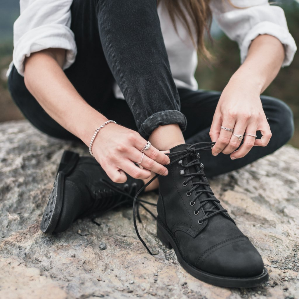 Black matte lace-up ankle boots with thick sole, worn with dark jeans