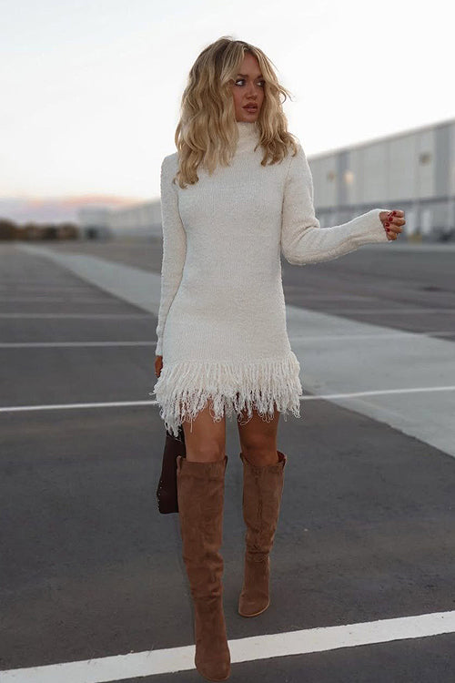 White knit tassel mini dress with long sleeves and fringe hem detail