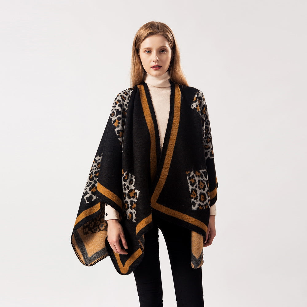 Black leopard-pattern cashmere scarf wrap with tan trim and draped sleeves