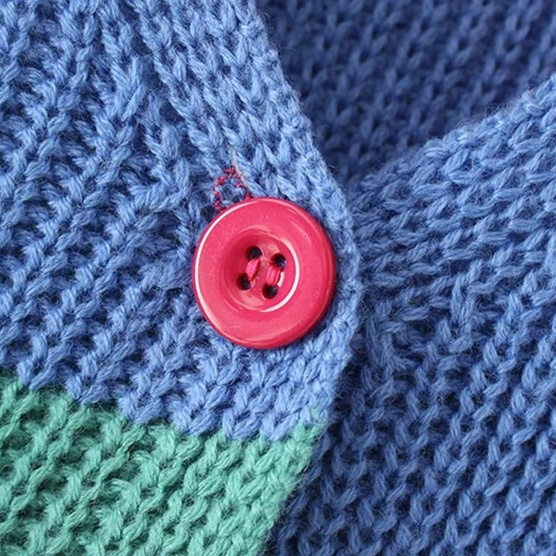 Knit cardigan fabric detail with blue-green stripes and pink button