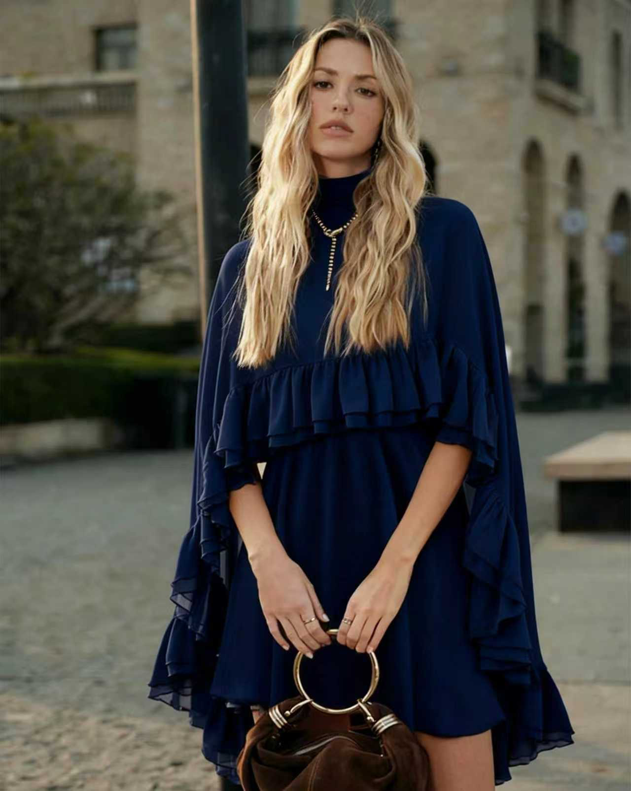 Navy chiffon mini dress with high neck, cape sleeves, and tiered ruffle hem.