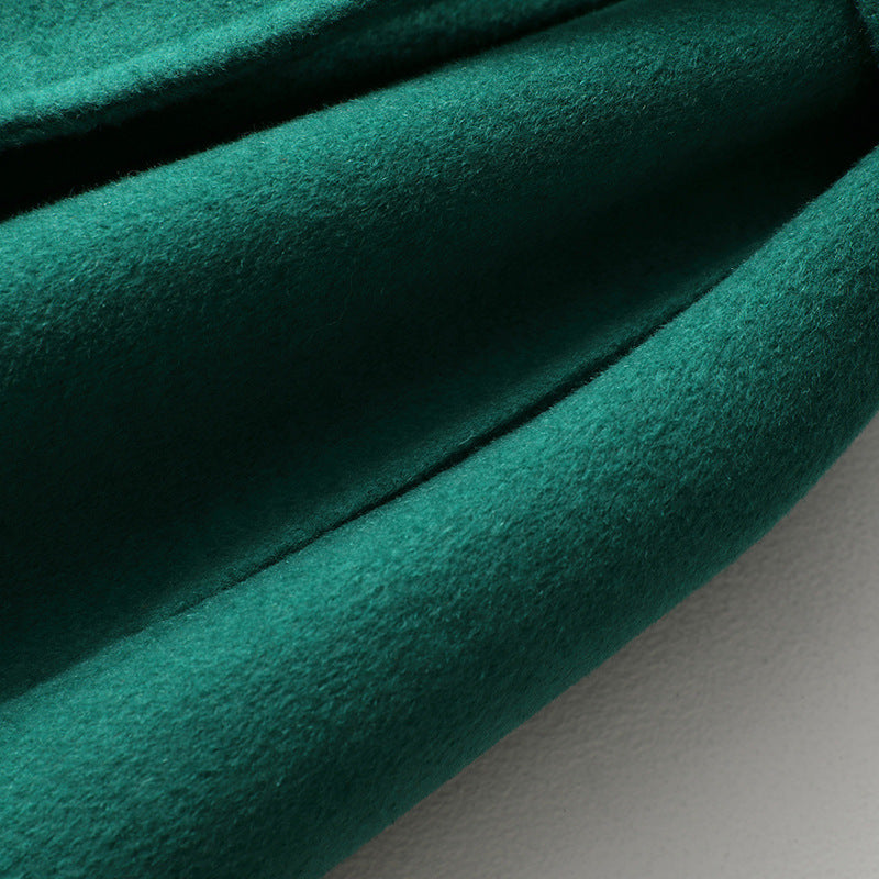 Close-up of green wool-cashmere coat fabric with soft textured weave.