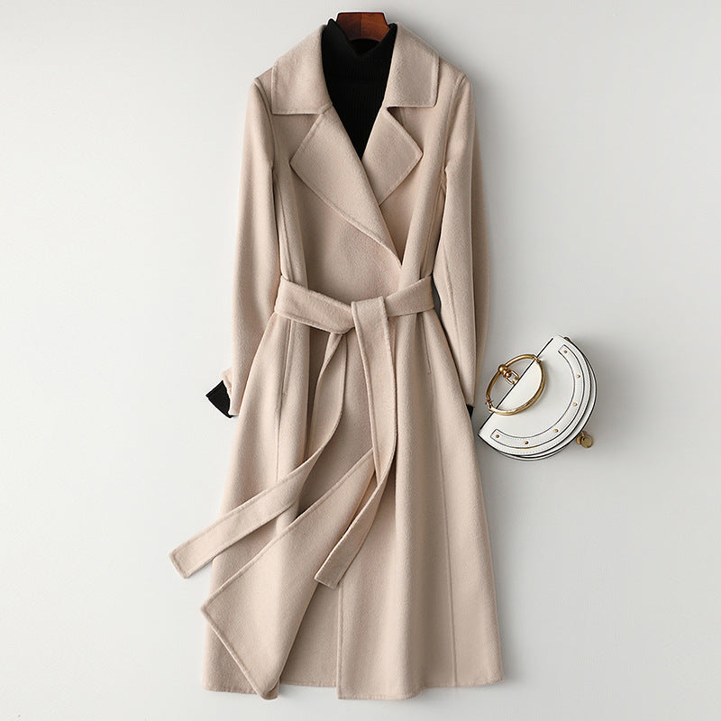 Women’s beige long wool-cashmere coat with notched lapels and tied waist belt.
