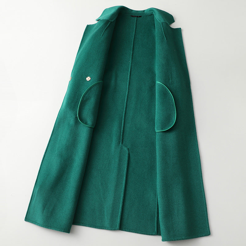 Women’s green long wool-cashmere coat with large patch pockets and belt.