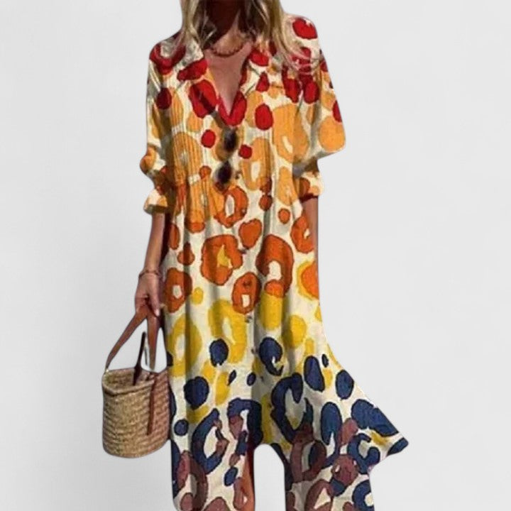 Boho printed maxi dress with yellow, red, and navy abstract pattern, V-neck button front