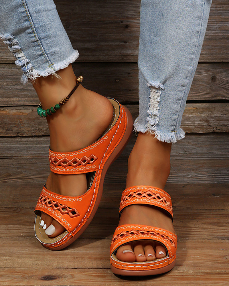Orange faux-leather flatform slip-on sandals with embroidered strap detail and beaded ankle strap
