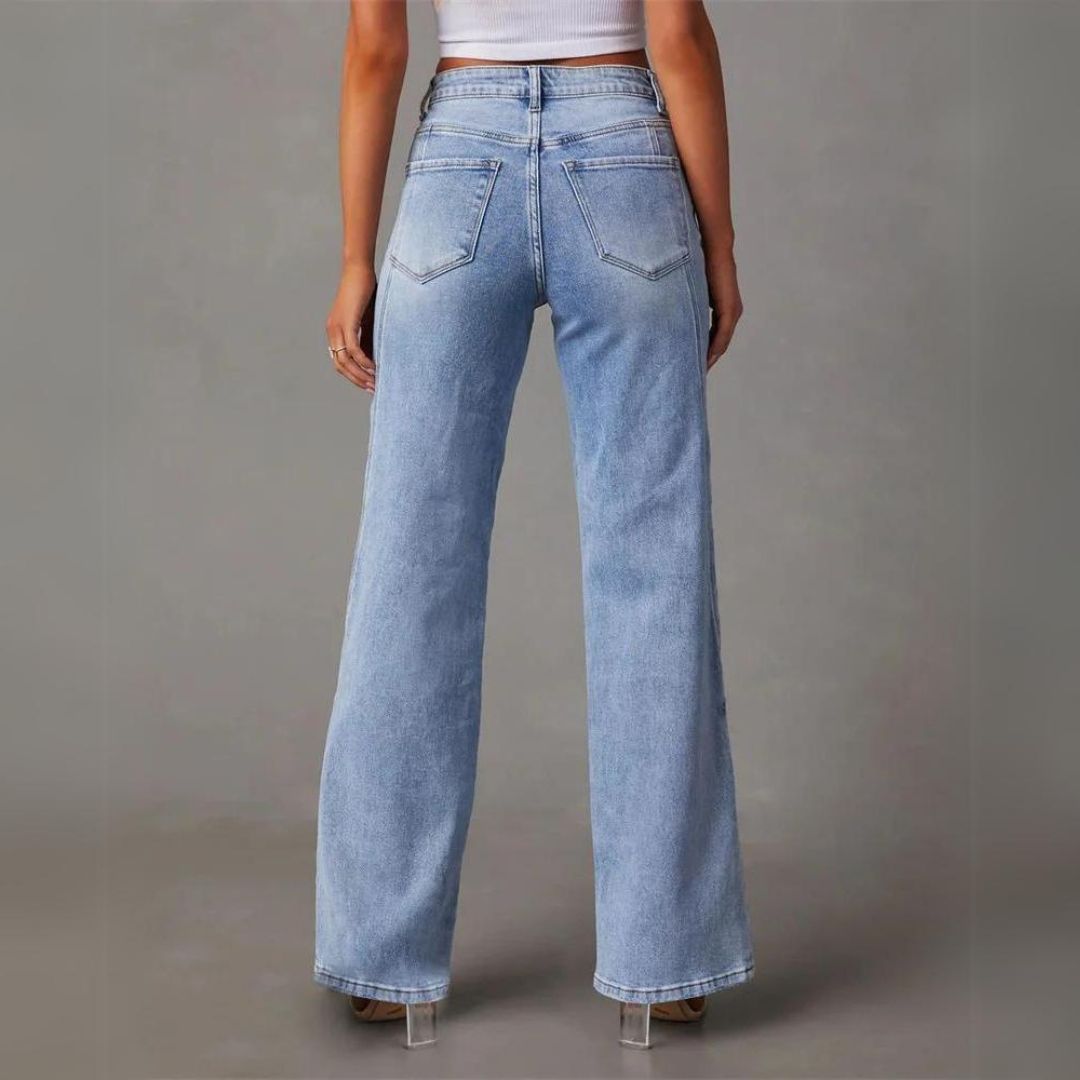 Women's high-rise blue flare jeans, back view with two welt pockets and seam