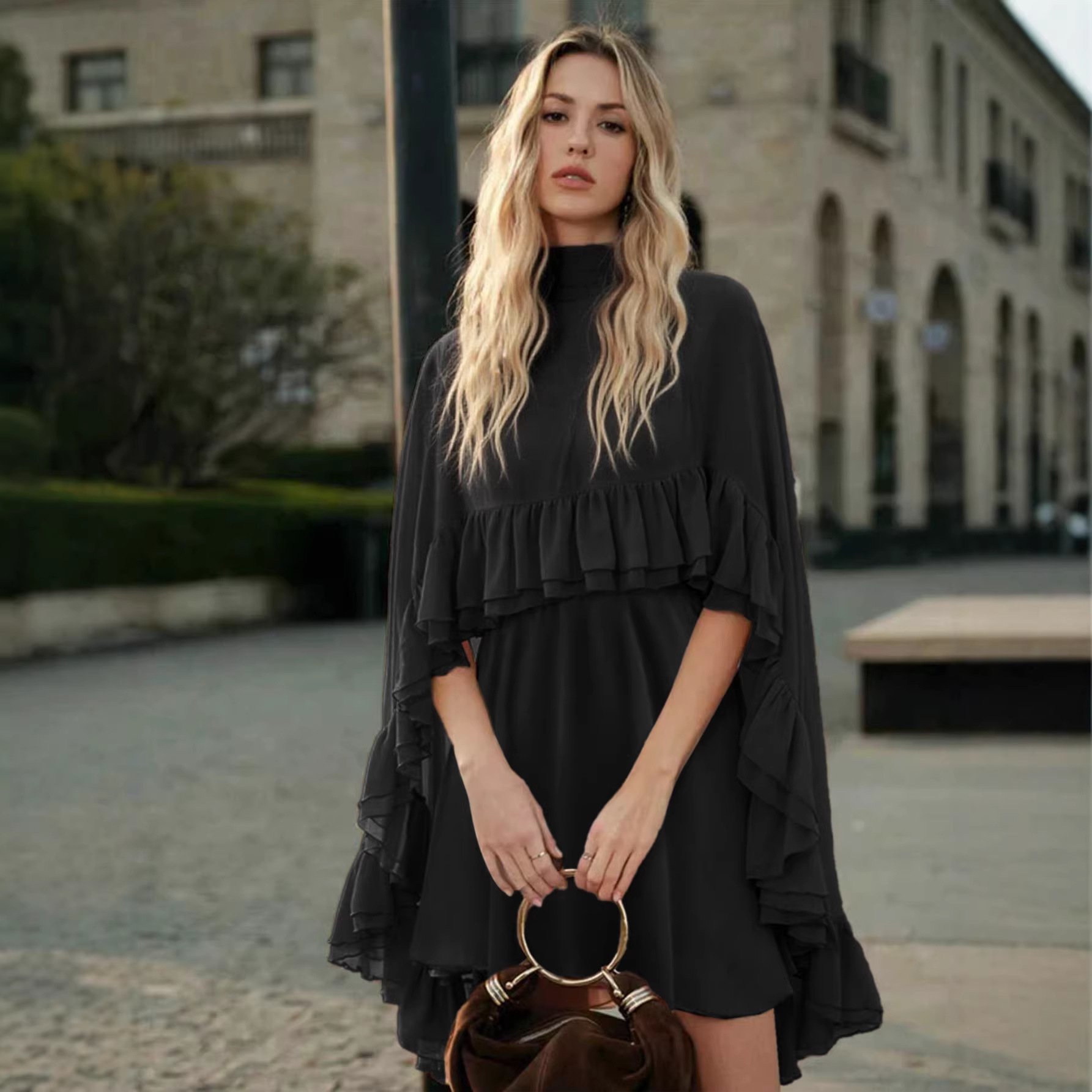 Black chiffon mini dress with high neck, cape sleeves, and tiered ruffle skirt