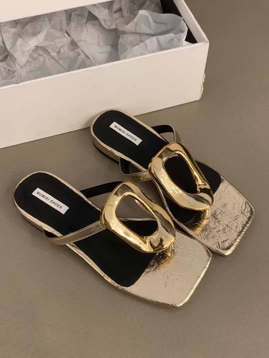 Black flat mules with sculptural gold hardware, square toe, open-back slip-on