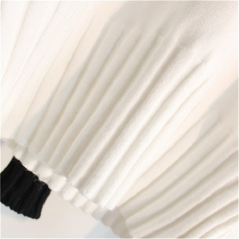 Women's white knit sweater sleeve and hem with ribbed cuff and gathered bottom
