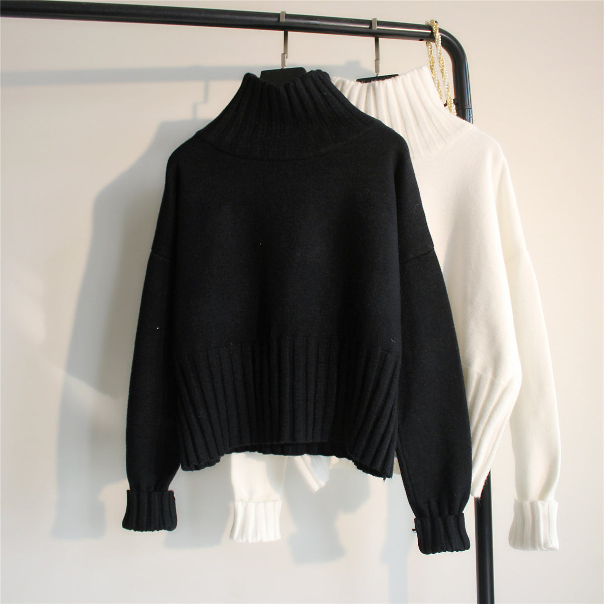 Women's black knit half-turtleneck sweater with loose fit and ribbed cuffs