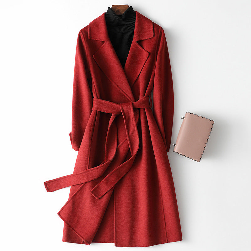 Women’s red long wool-cashmere coat with lapels and waist belt, patch details.