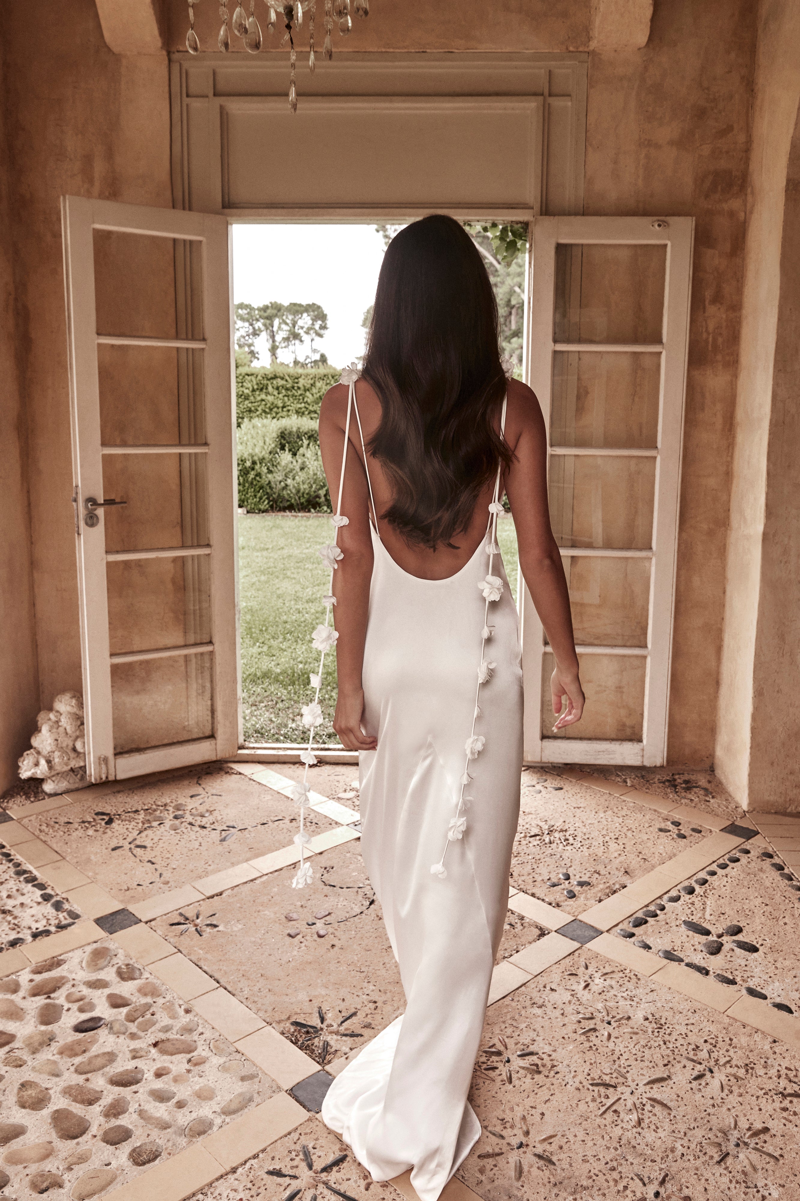 White satin slip maxi dress with open back and 3D floral strap details