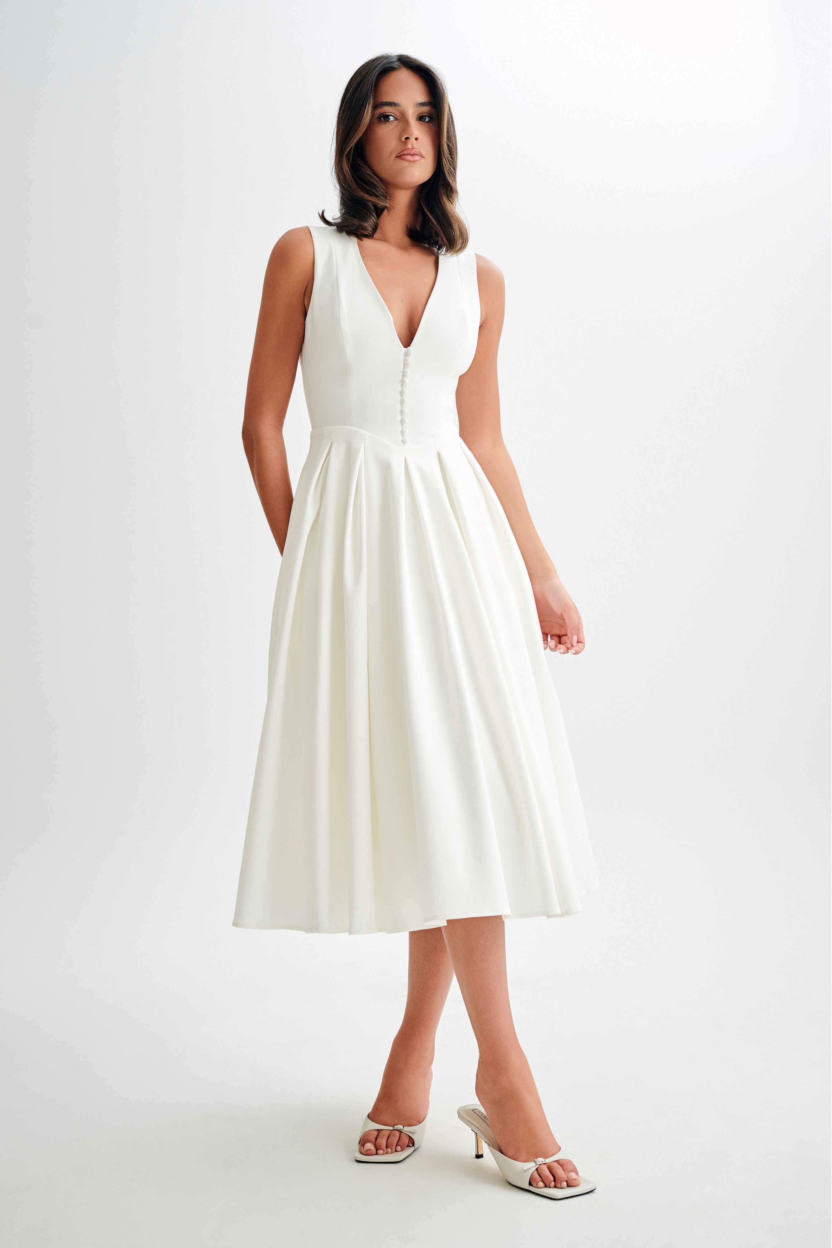 White satin A-line midi dress, sleeveless deep V front, buttoned bodice and pleated skirt