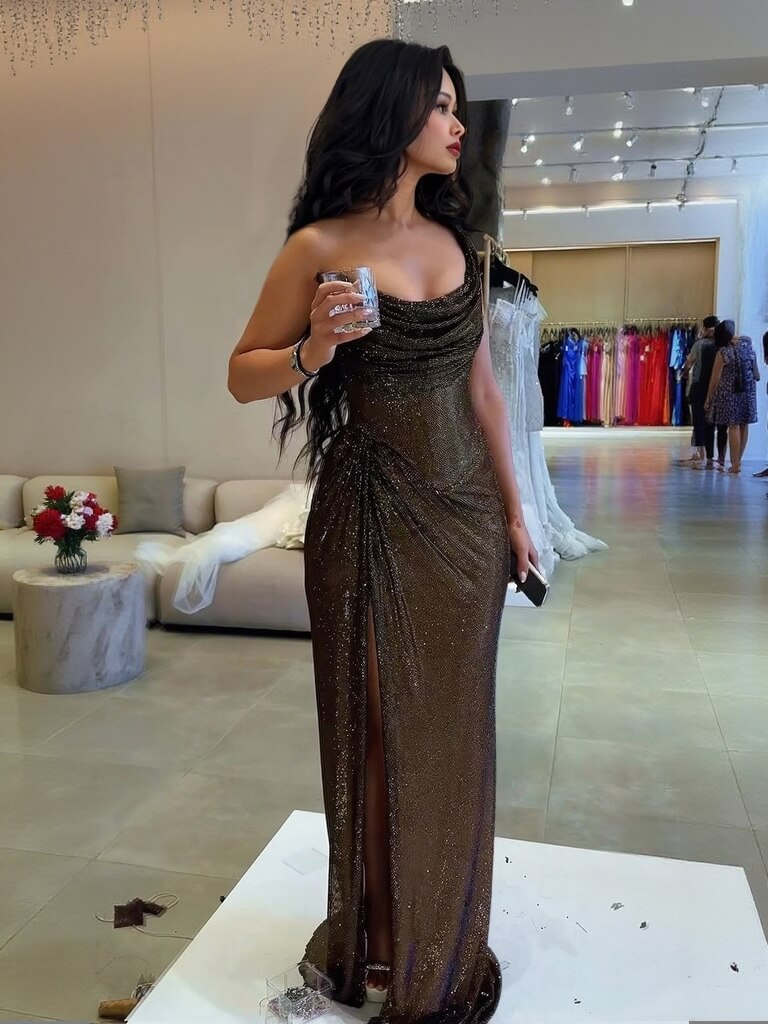 Black sequin bodycon maxi dress, side view, ruched waist, spaghetti straps, high slit.