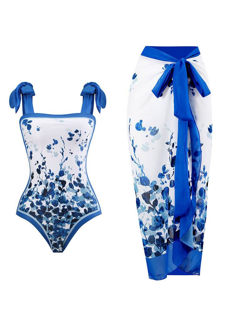 White one-piece swimsuit with blue splatter and tie straps; matching wrap sarong