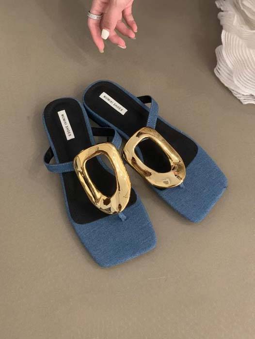 Blue flat mules with sculptural gold square-toe hardware and open-back slip-on