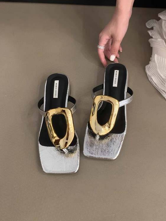 Light silver-toned flat mules with sculptural gold square-toe hardware and open back