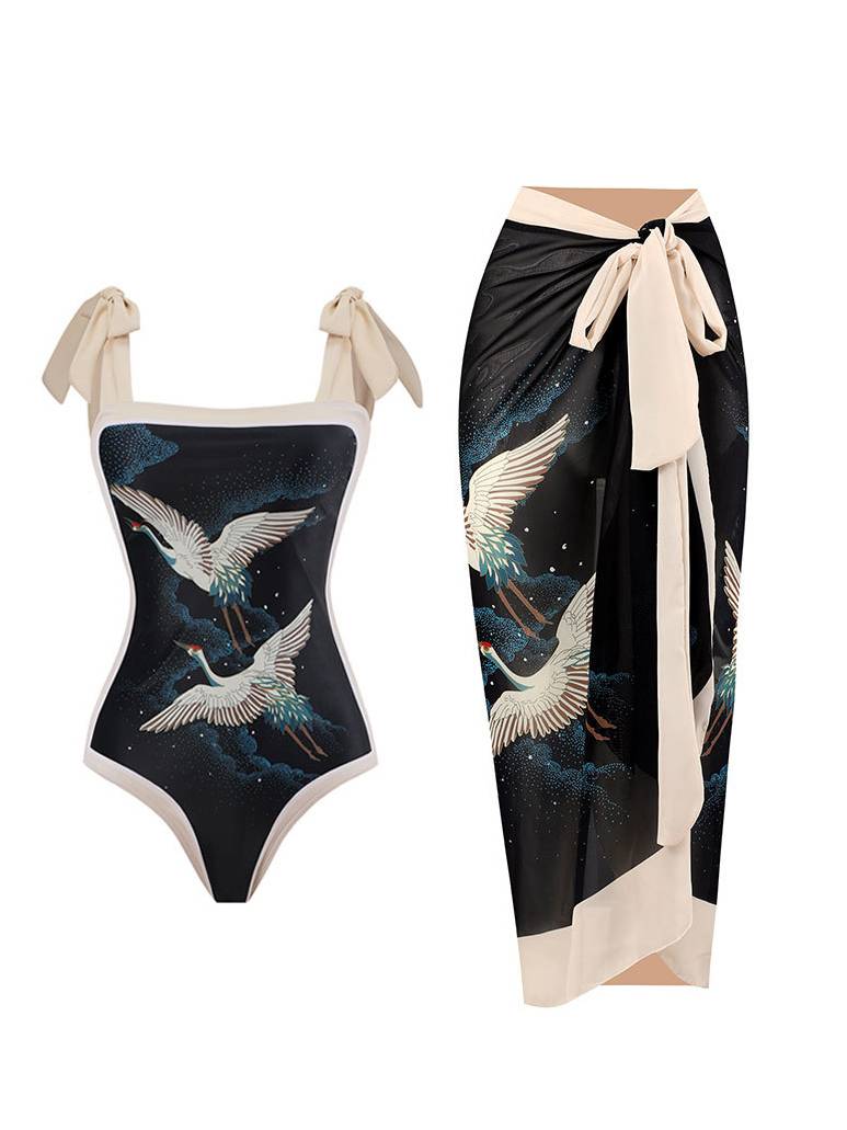 Black one-piece swimsuit with tie straps and bird print; matching wrap sarong in cream