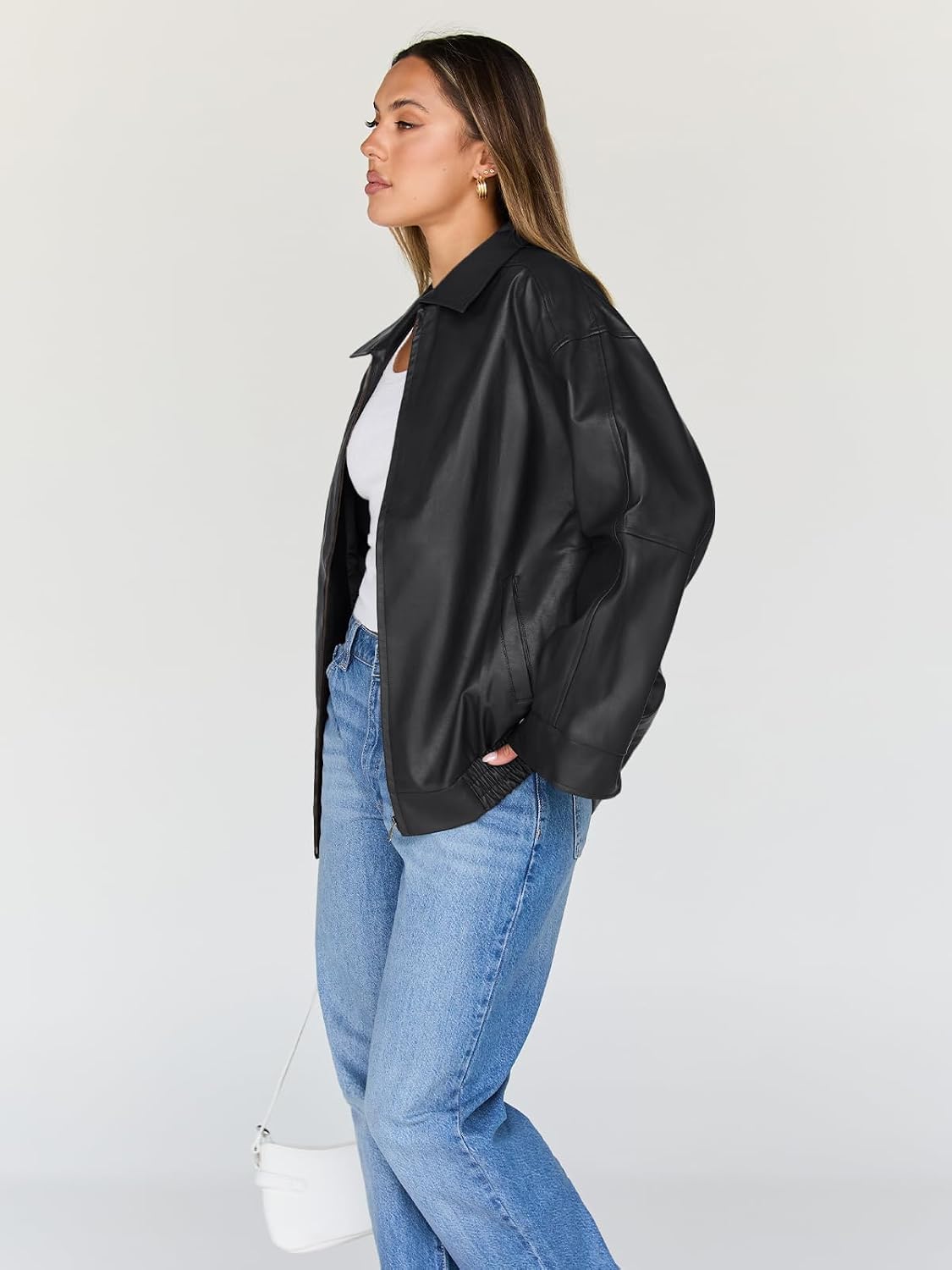Black oversized leather jacket shown from the side, with a wide collar and elastic hem