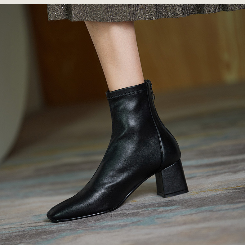 Black square-toe ankle boots with block heel and side zipper, leather-look sock bootie.