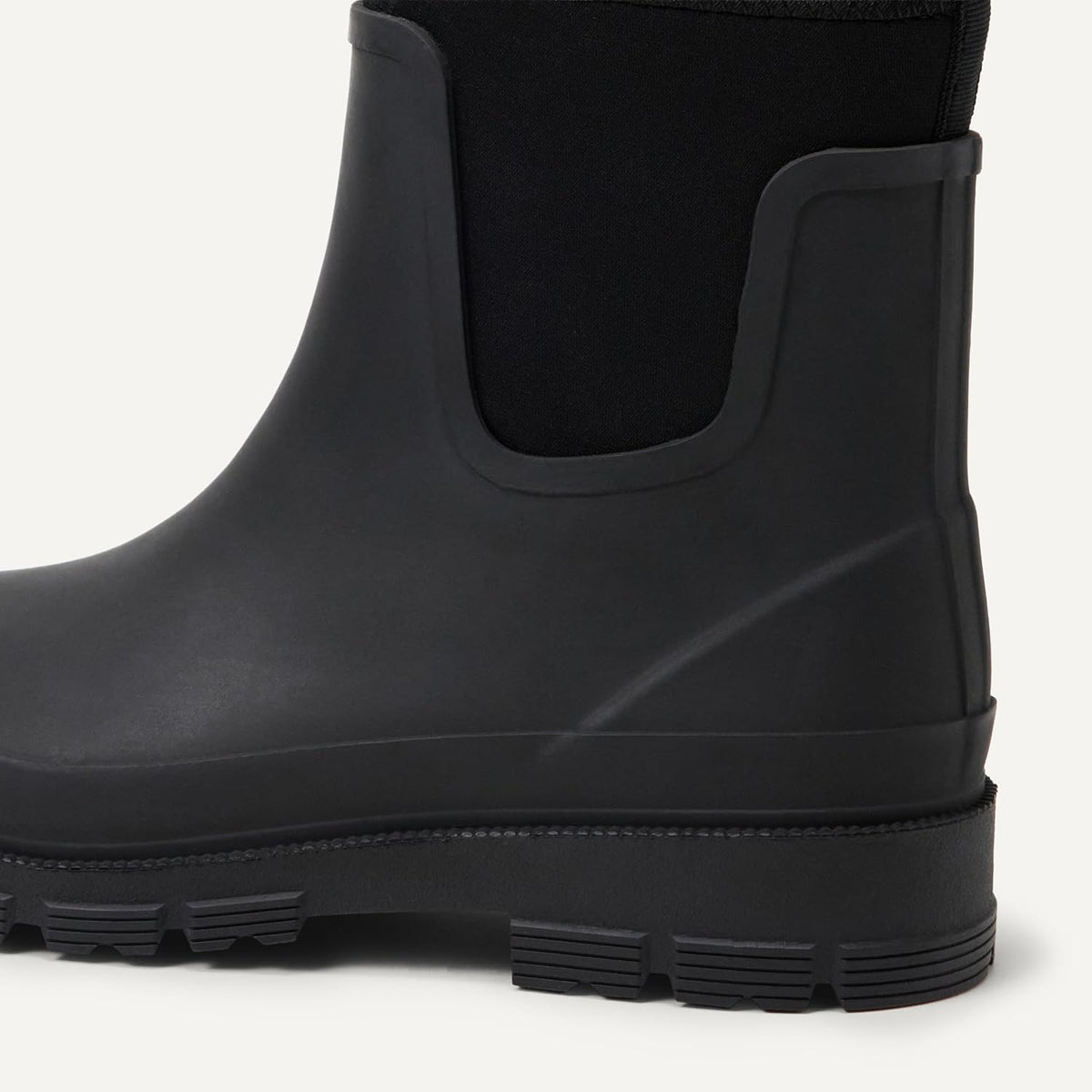 Black Chelsea rain boot close-up showing elastic side panel and lug sole