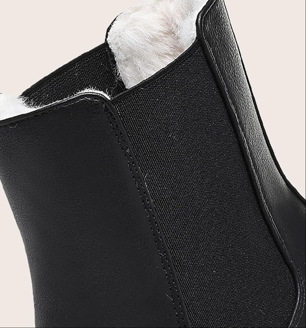 Close-up of a black boot's elastic side panel and plush fur lining