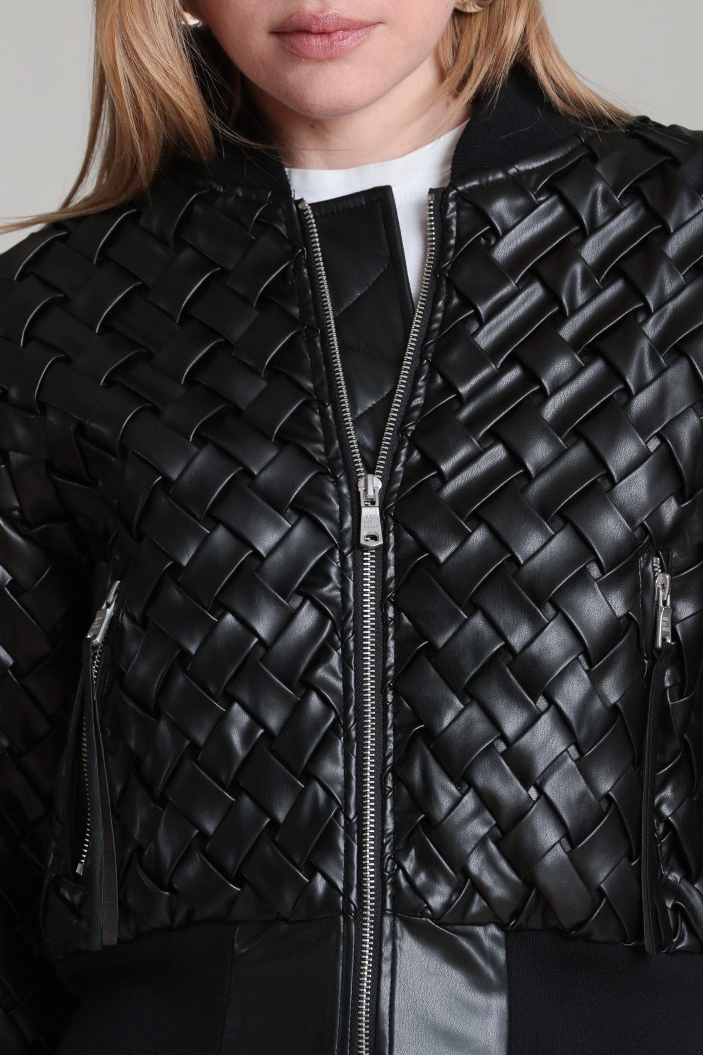 Black woven faux leather bomber jacket detail with front zipper and textured panels