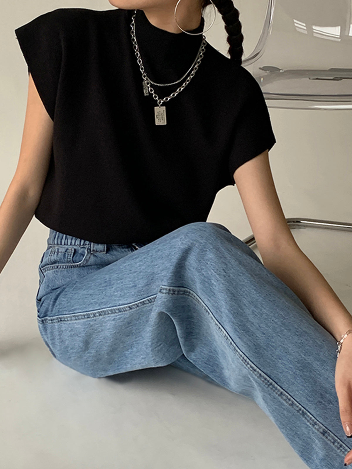 Black sleeveless mock neck knit top with short sleeves and relaxed fit