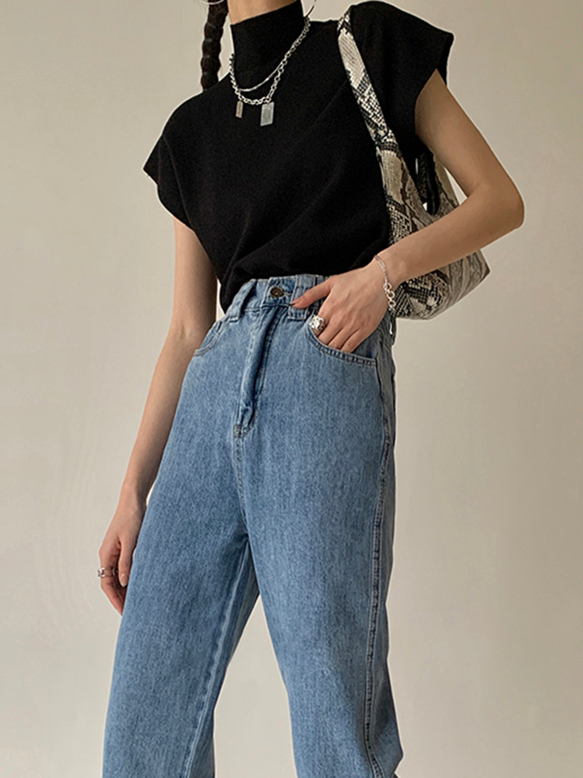 Black sleeveless mock neck knit top with short sleeves and ribbed neckline