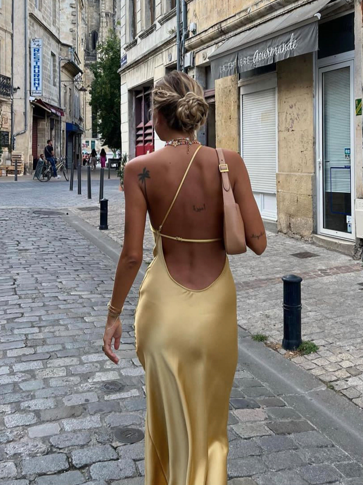 Yellow satin backless maxi dress with one-shoulder straps and cowl-style back