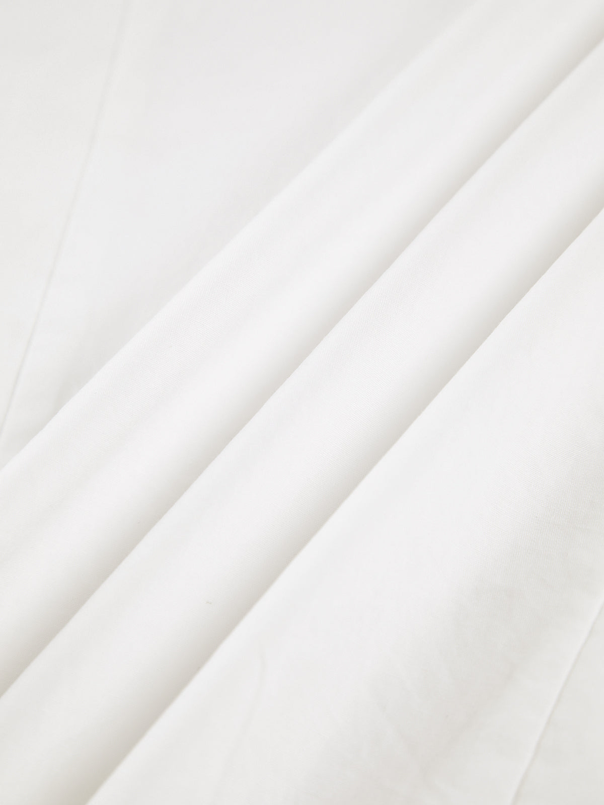 White cotton blouse fabric close-up with subtle texture