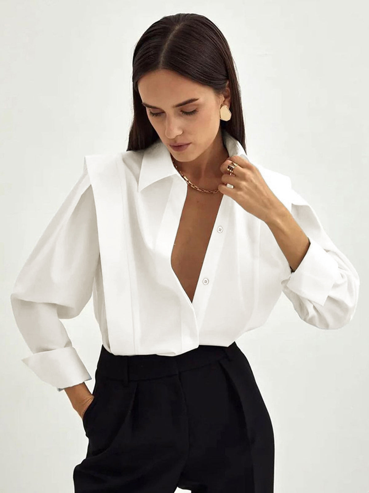 White cotton oversized button-down blouse with long sleeves and structured power shoulders