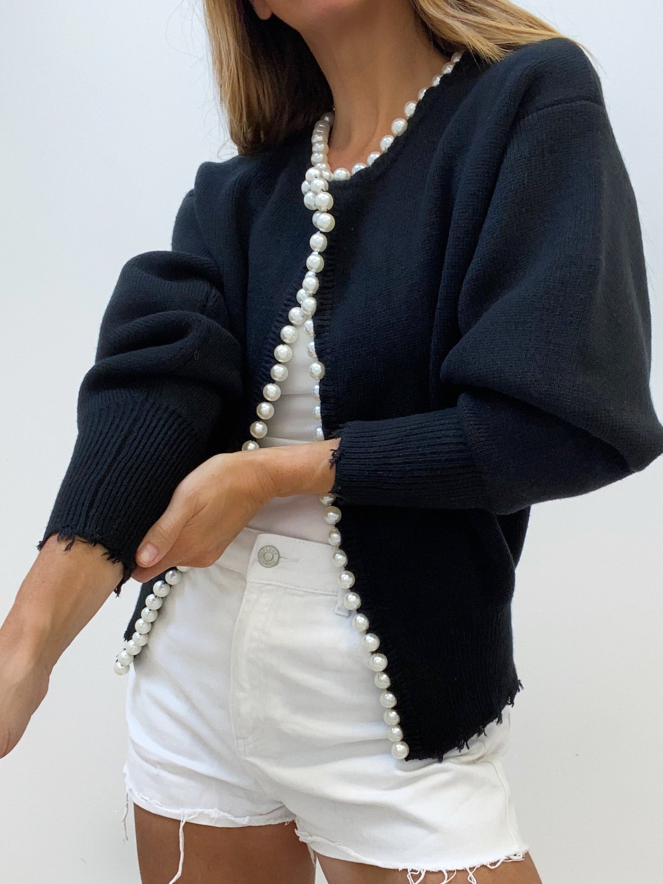 Women's black knit cardigan with open front and long pearl button trim, relaxed fit