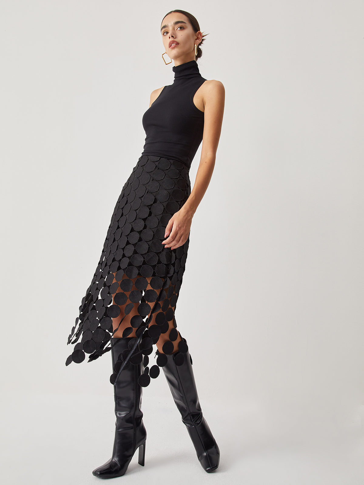 Black high-waist mesh midi skirt with circular disc overlay, side view