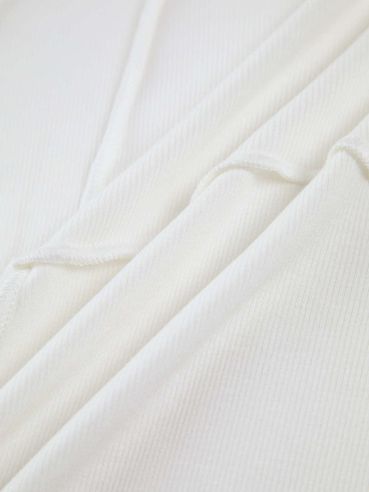Close-up of black ribbed knit fabric texture with fine vertical and diagonal ridges