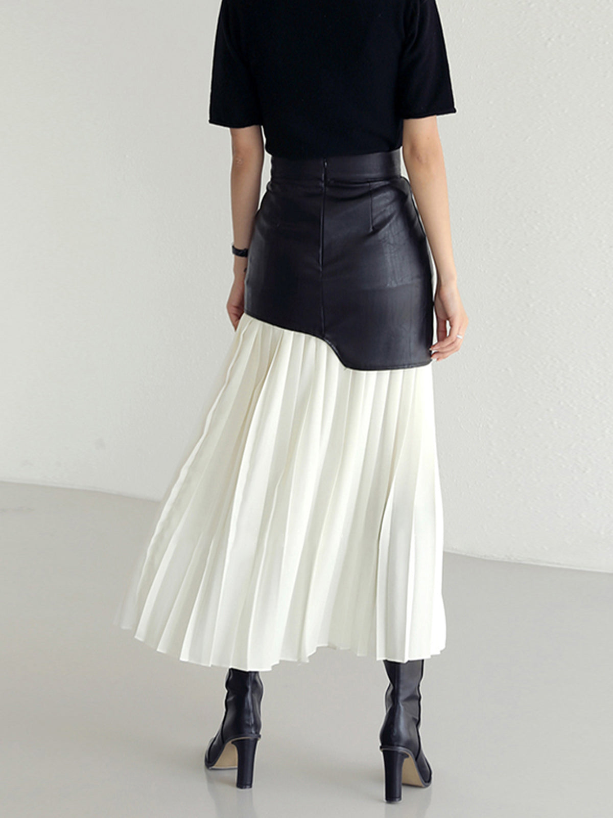 Two-tone leather maxi skirt with asymmetric waist yoke and white pleated skirt