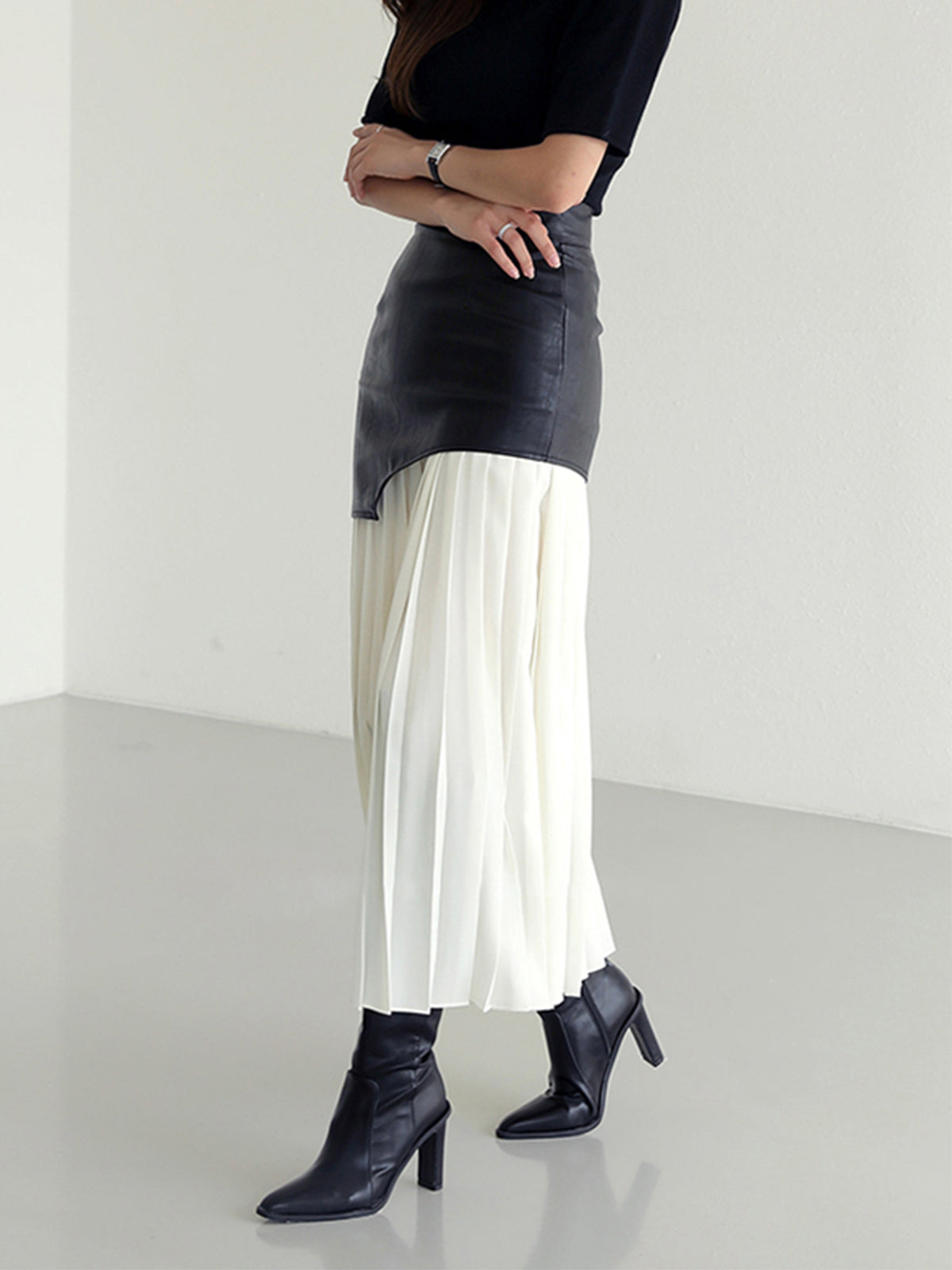 Black-and-white leather maxi skirt with high waist yoke and white pleated hem