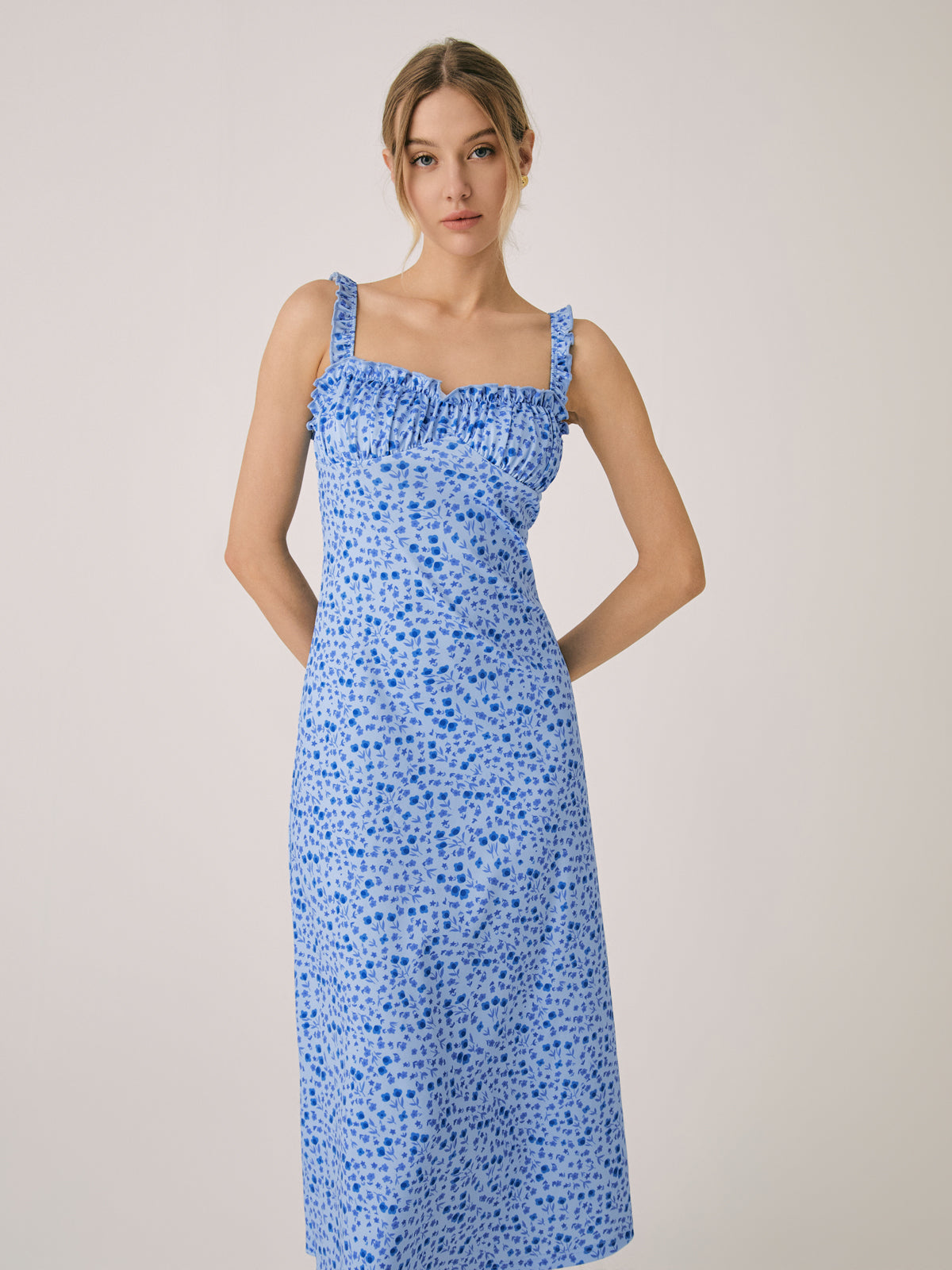 Blue floral midi dress with ruched bodice, spaghetti straps, and ruffle hem