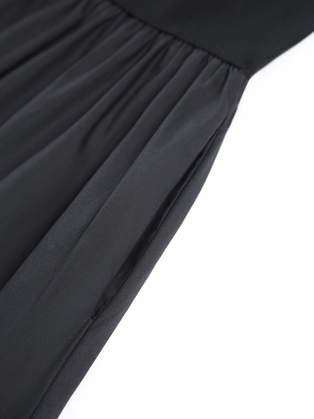 Black cotton fabric close-up of gathered seams and pleated skirt panels