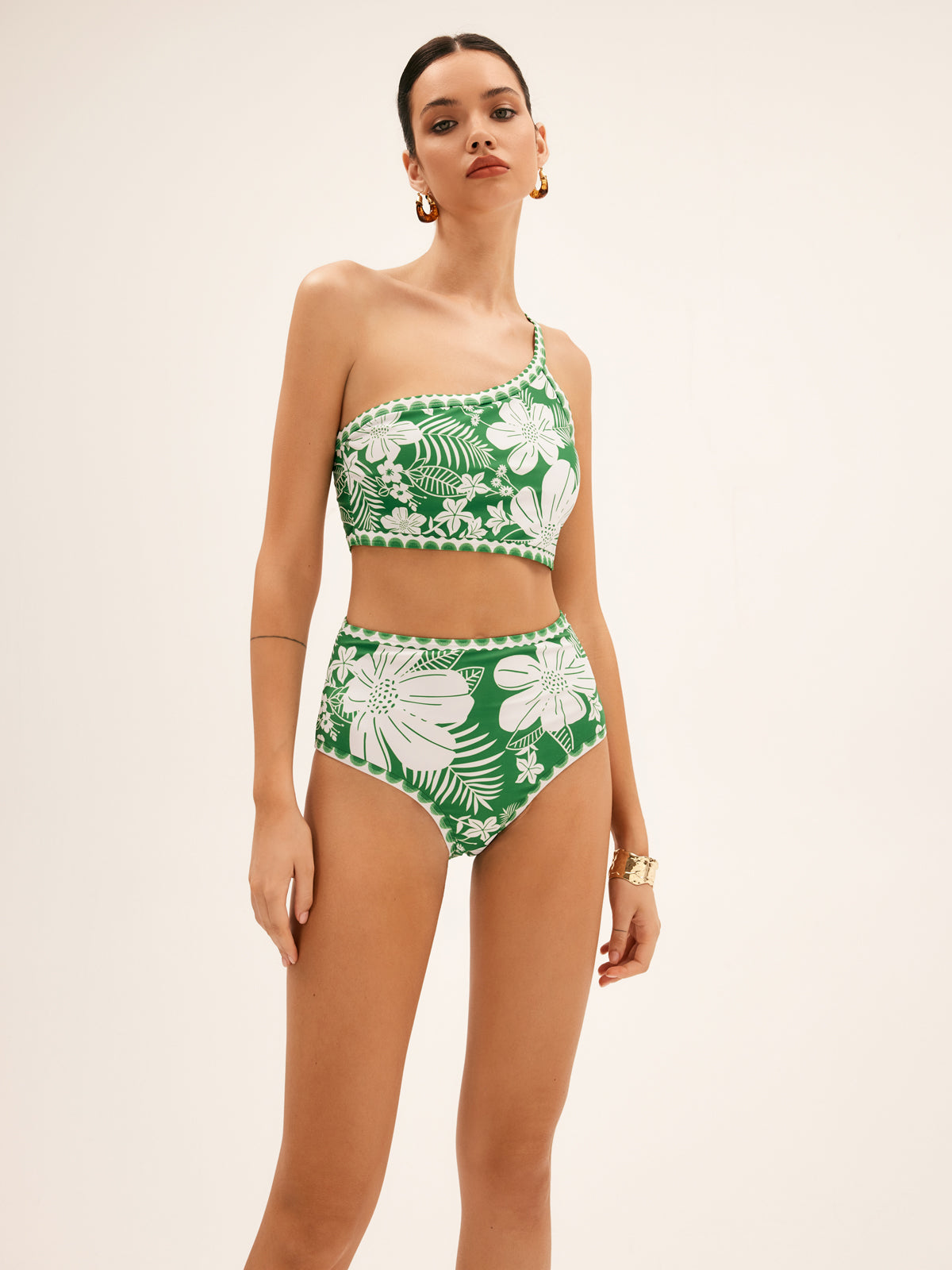 Green one-shoulder bikini set with tropical floral print; high-waist briefs, front view.