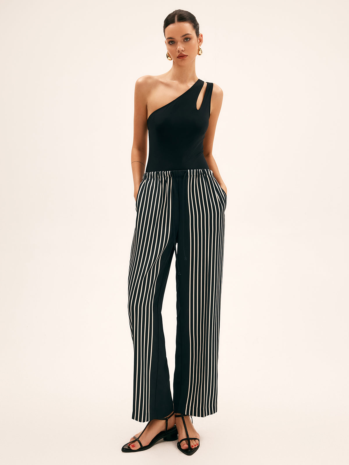 Black one-shoulder one-piece swimsuit on model with straight silhouette fit