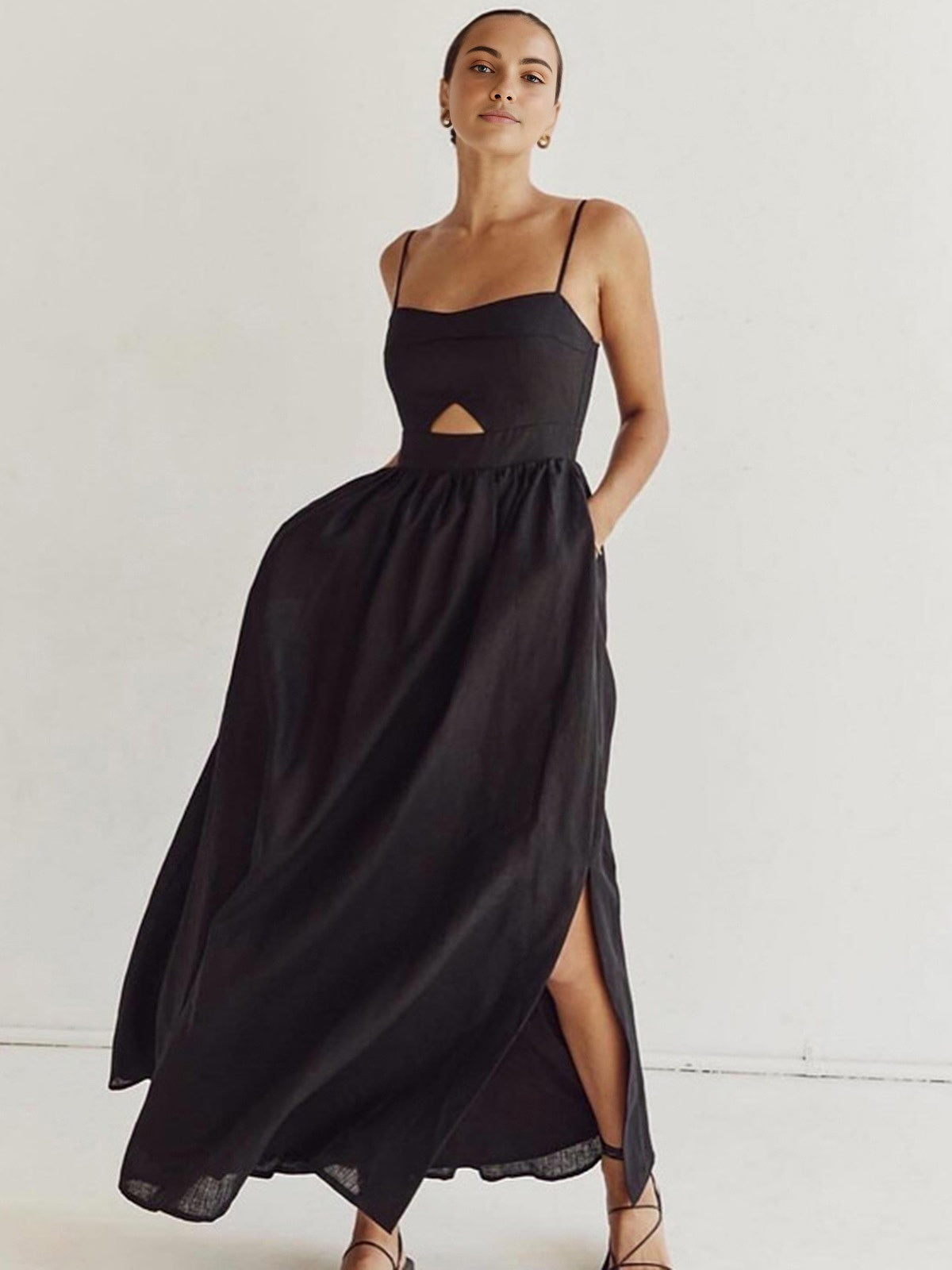 Black A-line maxi dress with spaghetti straps, cutout waist, and side slit