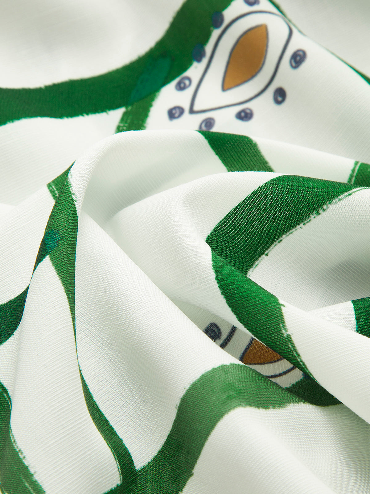 Close-up of white fabric with green and tan patterned print